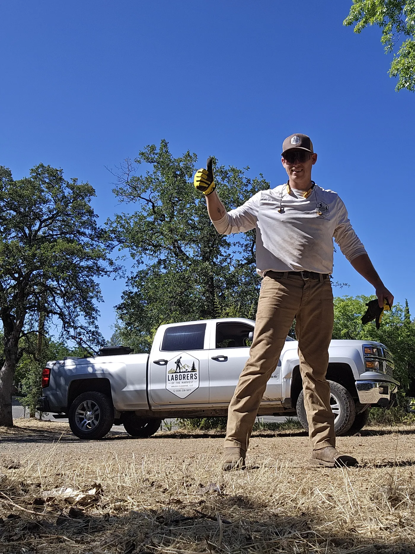 Grant Hatfield beside the Laborers of the Harvest truck on a cleared lot