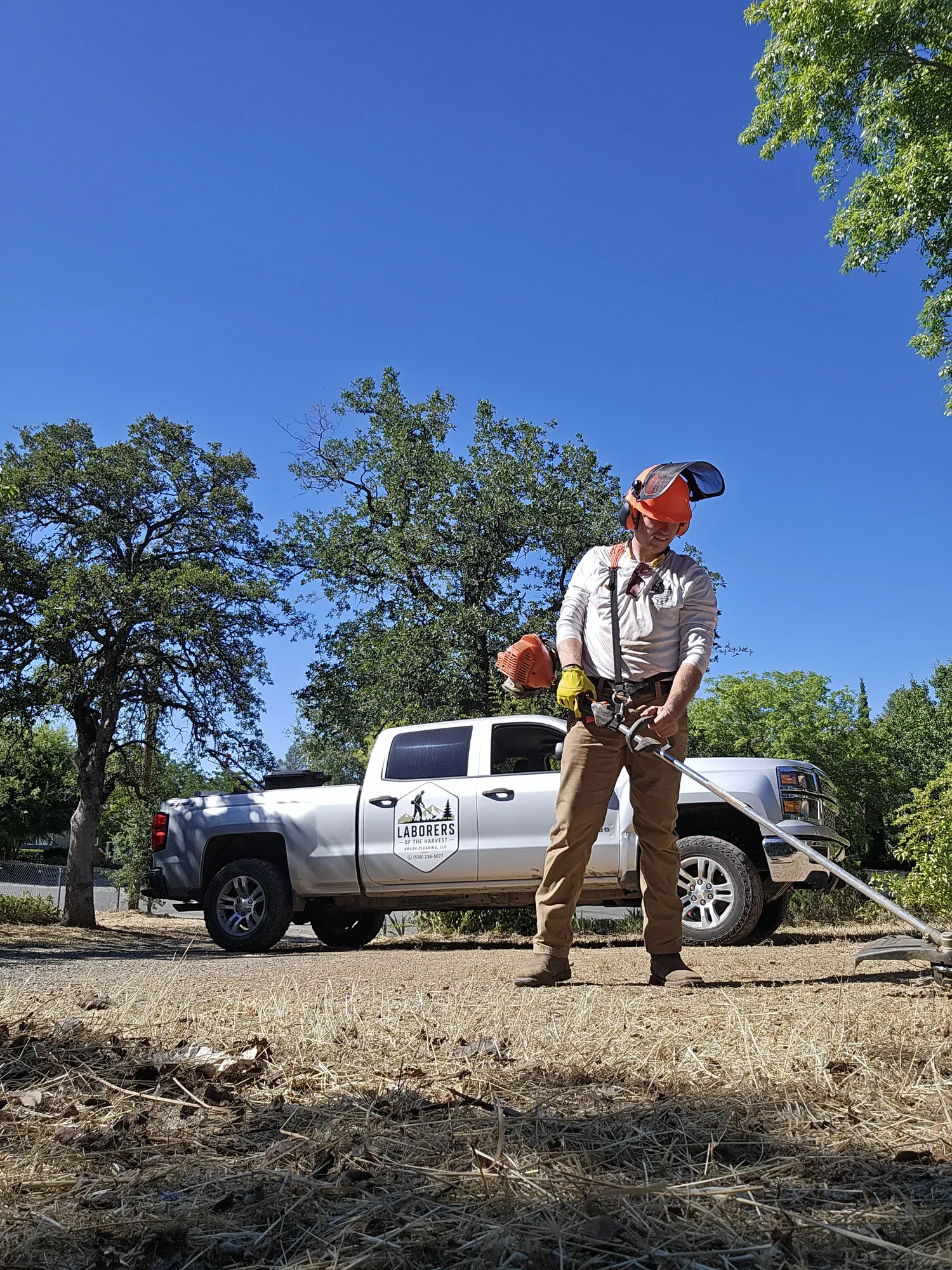 Crew member clearing a strip of ground along the road